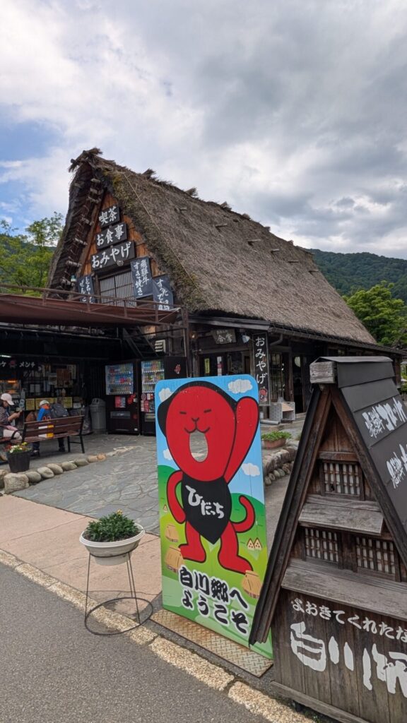 岐阜県白川郷にある合掌造りの建物「お食事処 合掌」。看板に描かれているキャラクターは「ひだっち」